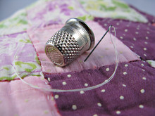 Silver Colored Thimble On An Old Antique Patchwork Quilt