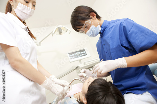 女性患者の治療をする男性歯科医と歯科衛生士 Stock Photo Adobe Stock