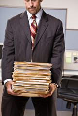 Canvas Print - Businessman carrying stack of file folders