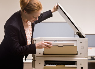 Canvas Print - Businesswoman copying papers in office