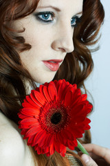 The beautiful young girl with a red flower