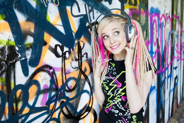 Wall Mural - portrait of young woman with headphones at graffitti wall