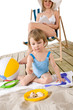 © CandyBox Images - Beach - Mother with child playing with toys in sand