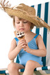 © CandyBox Images - Beach - Little girl on deck-chair with hat and ice-cream