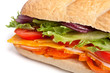 long baguette sandwich with lettuce, slices of fresh vegetables,