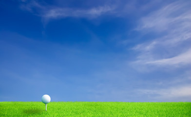  Golf ball on grass under blue sky and clouds