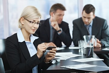 Wall Mural - Businesswoman using smartphone in office