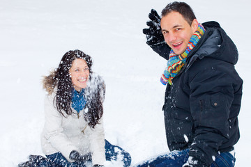 Young couple playing outdoors in the snow.