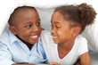 © WavebreakMediaMicro - Portrait of laughing siblings lying down on bed