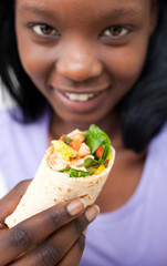 Attractive Afro-american woman eating a wrap