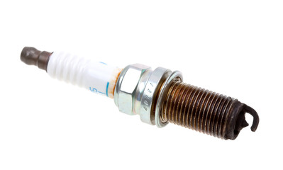 Close-up old burned spark plug on white