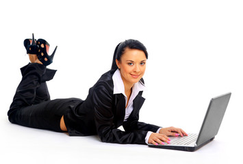 young woman is lying on the floor and working on a laptop