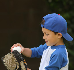 Hispanic boy playing with baseball and glove