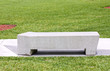 concrete bench and path in park with green grass