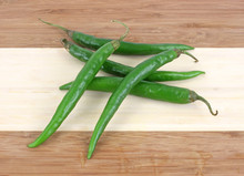 Long Green Hot Peppers On Wood Cutting Board