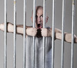 jeune homme hurlant derrière les barreaux prison