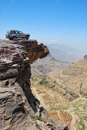 Fototapeta na wymiar Lone car is standing on rock over breakaway