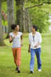 © Don Mason/Blend Images - African American mother and adult daughter walking in park