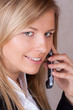 Closeup of business woman with mobile phone and smiling
