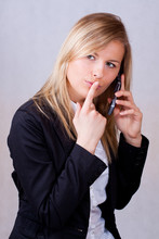 Business Woman With Mobile Phone And Finge On Mouth