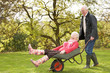 © micromonkey - Senior Couple Man Giving Woman Ride In Wheelbarrow