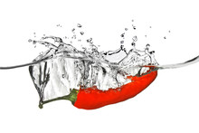 Red Pepper Dropped Into Water With Splash Isolated On White