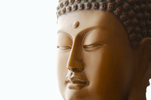 Close Up Of Buddha Head Carving Against White Background