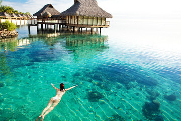 Wall Mural - Young woman swimming in a coral lagoon