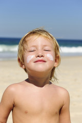 cute child with sunscreen at the beach