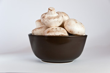 White mushrooms in a brown bowl