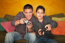 Hispanic Man And Boy Playing Video Game
