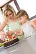 © CandyBox Images - Mother and child with chocolate cake in kitchen