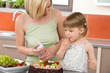© CandyBox Images - Mother and child with chocolate cake in kitchen
