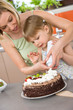 © CandyBox Images - Mother and child with chocolate cake in kitchen