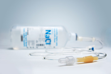 Poster - Saline IV drip on blue background in shallow depth of field