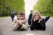 Happy young couple lying on the road