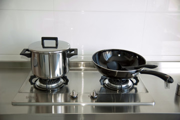 Two  stainless steel pots on a gas stove