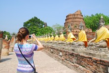 Tourist With Camera In Front Of Budha Statues