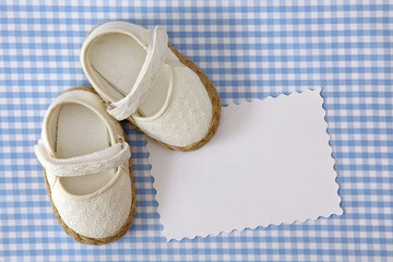 Wall Mural - Baby shoes and blank note on blue background