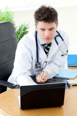 Wall Mural - Confident male doctor using a laptop