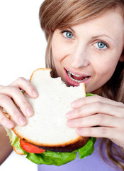 Wall Mural - Blond woman eating a sandwich