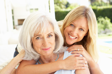 Portrait Of Mother And Adult Daughter Relaxing On Sofa