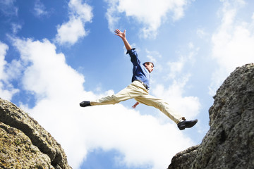businessman jumping over the mountains, business concept