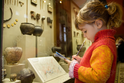 Fotografie, Obraz little girl writes to writing-books at excursion in museum