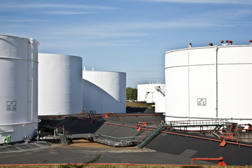 white tanks in tank farm with blue sky