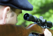 Man Looking Through Scope On A Rifle Gun