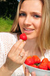Junges Mädchen mit einer Schale roter Erdbeeren