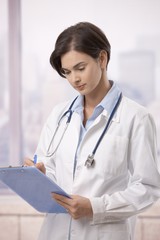 Wall Mural - Female doctor doing paperwork in hospital