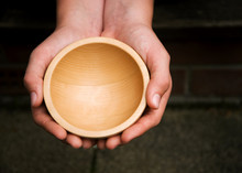 White Hands Holding A Wooden Begging Bowl