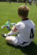 © travelview - exausted boy takes a rest in the halftime of a football match